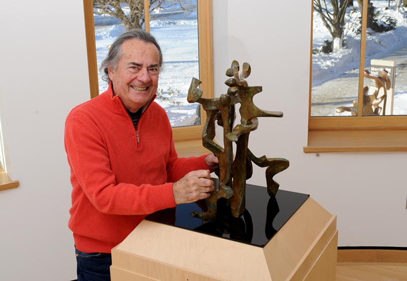 Bill Barrett smiling with a maquette of his bronze sculpture Bravo 3