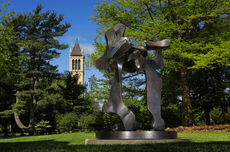 Photo of Bravo 3 a bronze sculpture outdoors with trees and a campanile in the background
