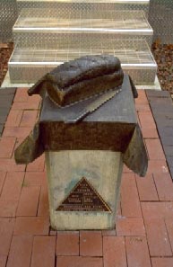 Photo of a metal sculpture of bread on a concrete pedestal