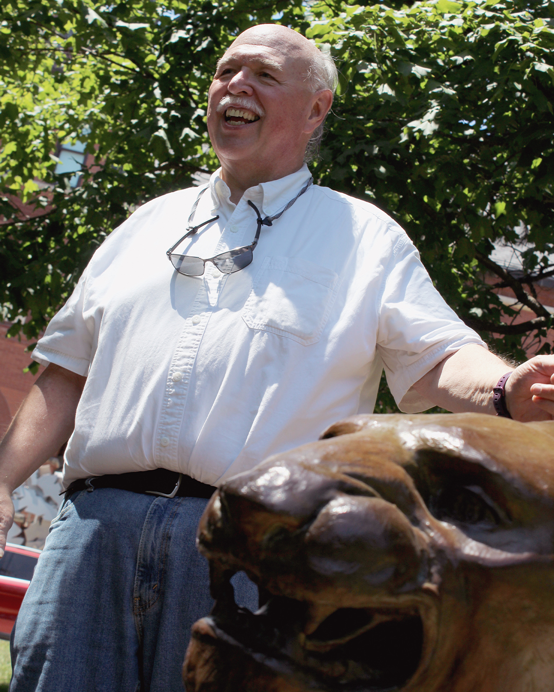 Photo of Rick Bartosh outside with a panther sculpture